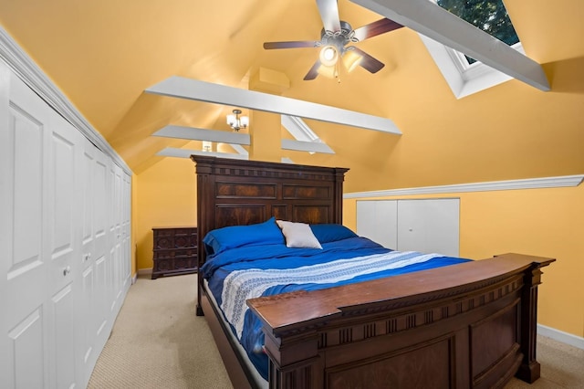 carpeted bedroom featuring ceiling fan, vaulted ceiling with skylight, and a closet