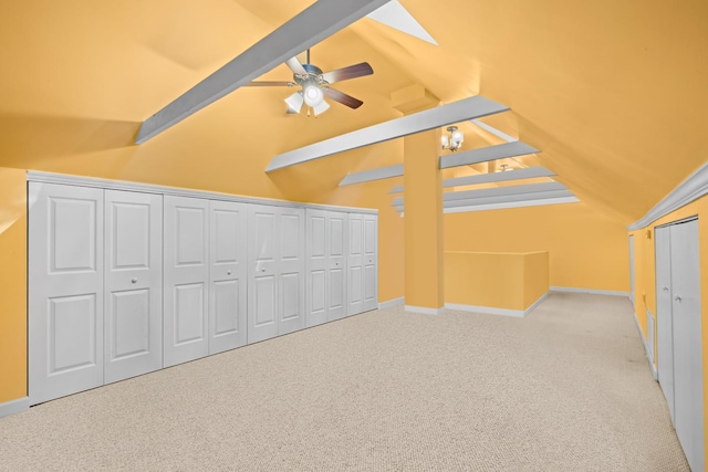 additional living space featuring lofted ceiling with skylight, light colored carpet, and ceiling fan