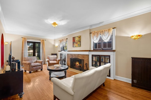 living room with ornamental molding, wood-type flooring, and a fireplace