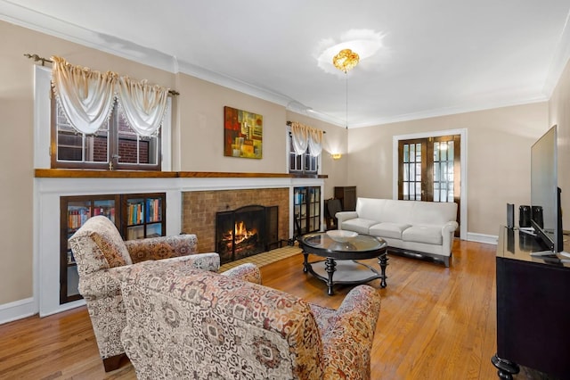 living room featuring hardwood / wood-style flooring, crown molding, a brick fireplace, and french doors