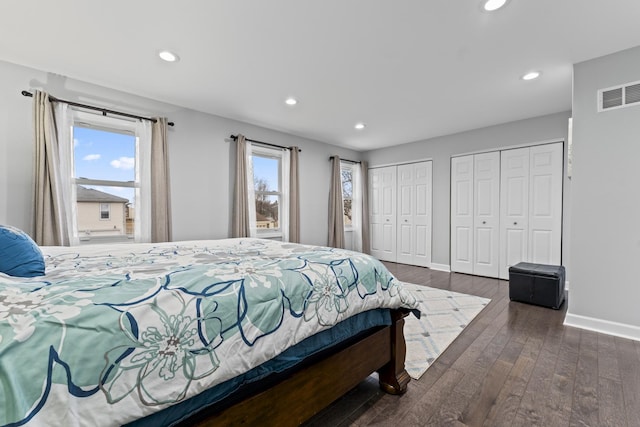 bedroom featuring multiple closets and dark hardwood / wood-style floors