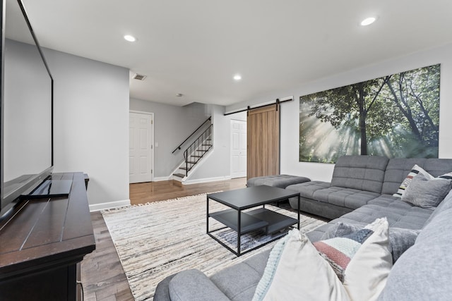 living room with wood-type flooring and a barn door