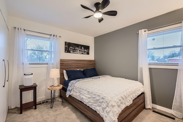 bedroom featuring light carpet, ceiling fan, and baseboards