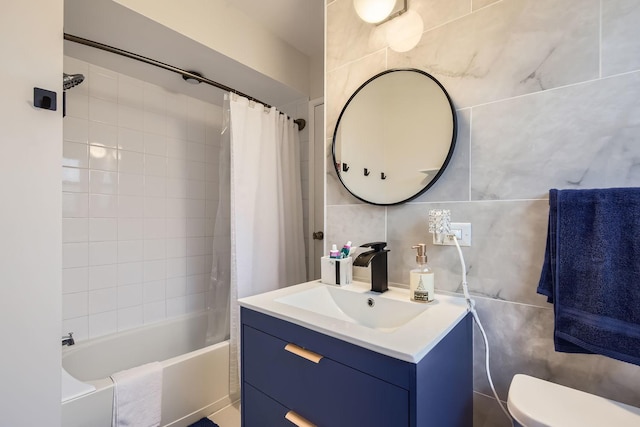 full bath with toilet, vanity, tile walls, and shower / tub combo with curtain