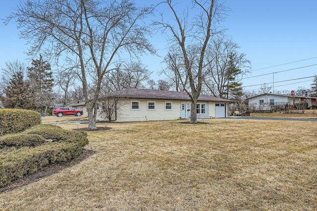 view of front of home with an attached garage and a front lawn