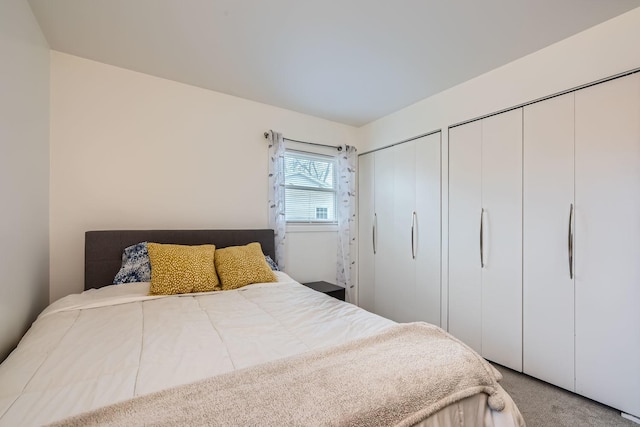 bedroom with carpet flooring and multiple closets