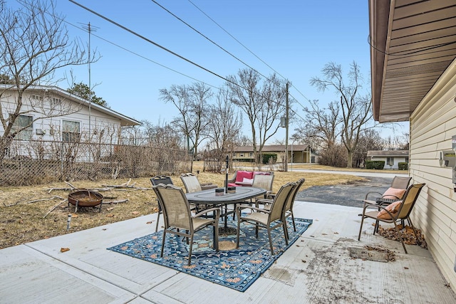 view of patio with an outdoor fire pit, fence, and outdoor dining space