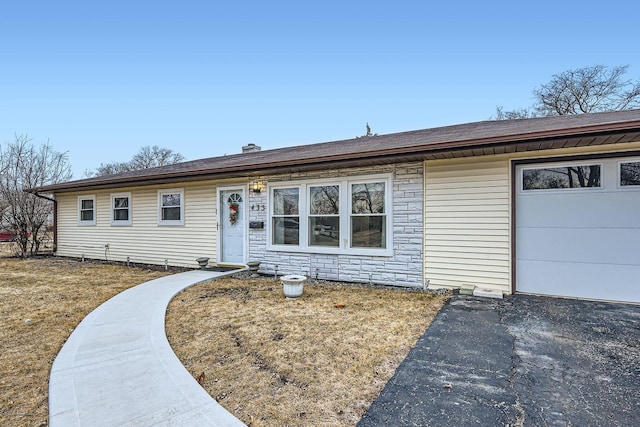 ranch-style home featuring stone siding and an attached garage