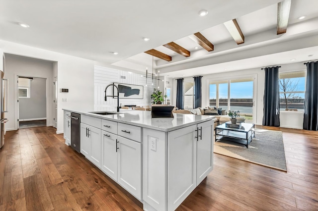 kitchen with white cabinetry, sink, dark hardwood / wood-style floors, and an island with sink