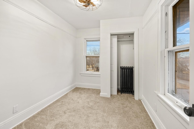 unfurnished bedroom with radiator, light colored carpet, and a closet