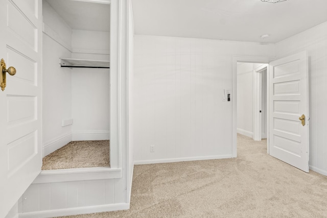 unfurnished bedroom featuring light colored carpet and a closet