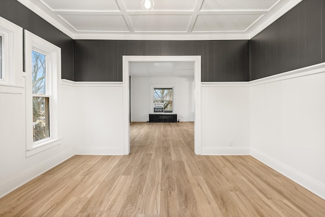 unfurnished room with coffered ceiling and light hardwood / wood-style floors