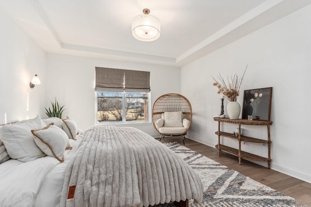 bedroom featuring dark wood-type flooring and a raised ceiling