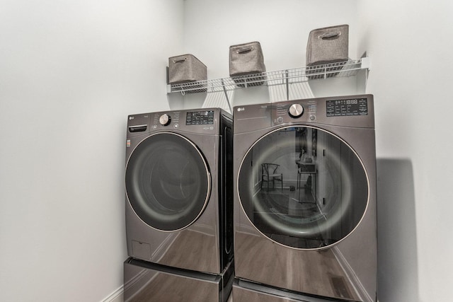 clothes washing area with hardwood / wood-style flooring and washing machine and clothes dryer