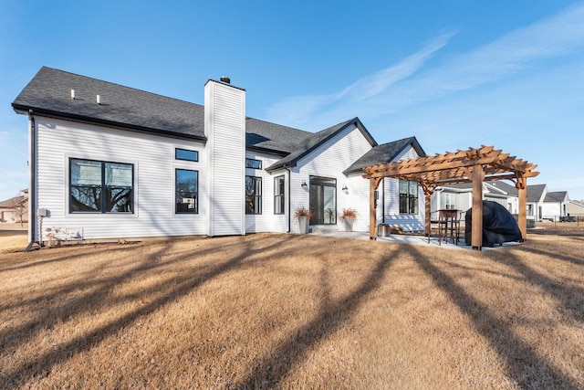 rear view of property with a patio, a yard, and a pergola