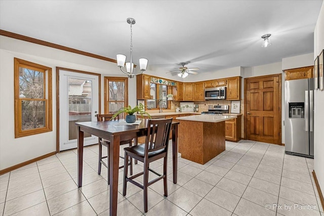 tiled dining area with a healthy amount of sunlight and ceiling fan with notable chandelier