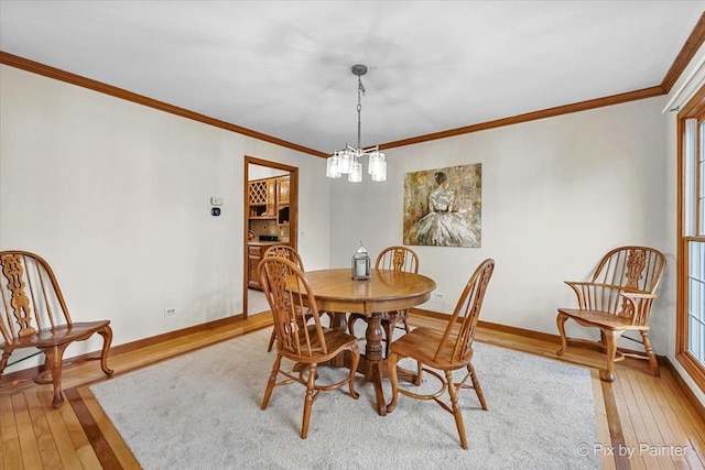 dining area featuring a notable chandelier, crown molding, and light hardwood / wood-style flooring