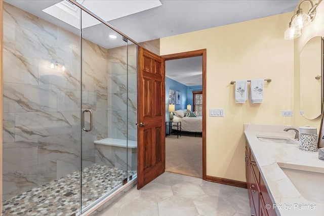 bathroom featuring a shower with door, vanity, and a skylight