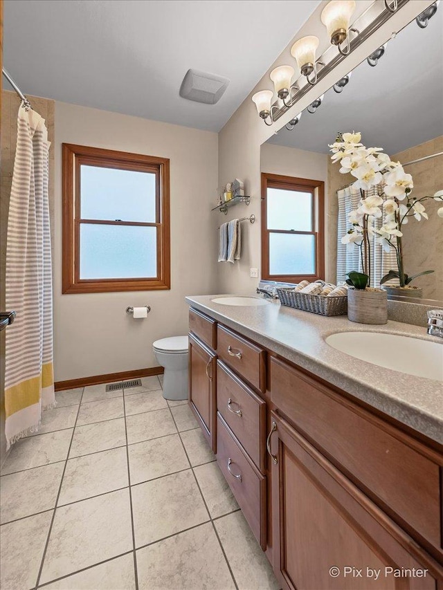 bathroom with tile patterned flooring, vanity, and toilet