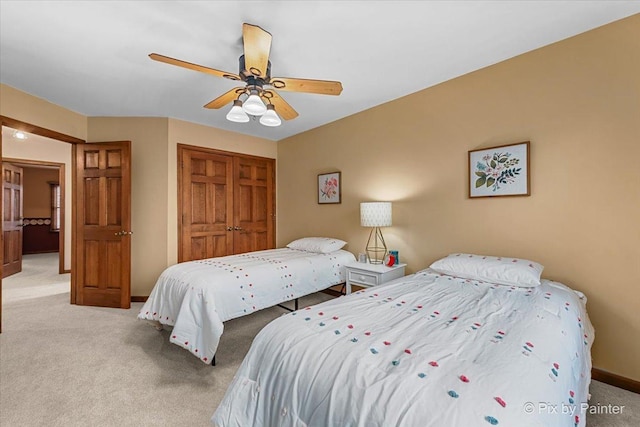 bedroom featuring light carpet, ceiling fan, and a closet