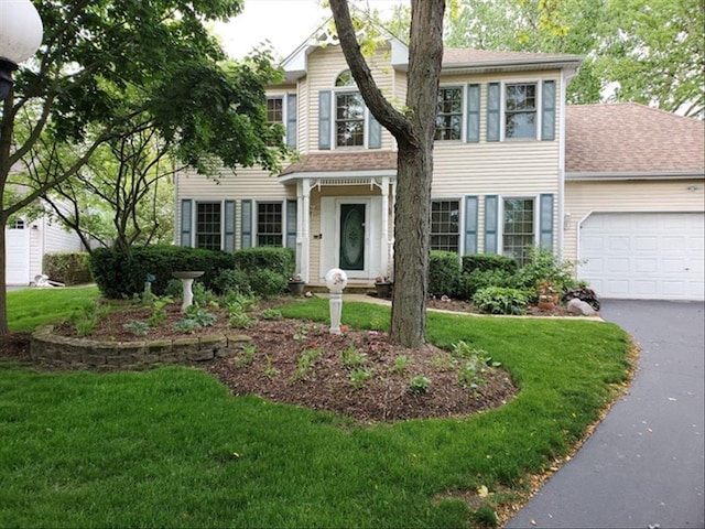 view of front of house featuring a garage and a front lawn