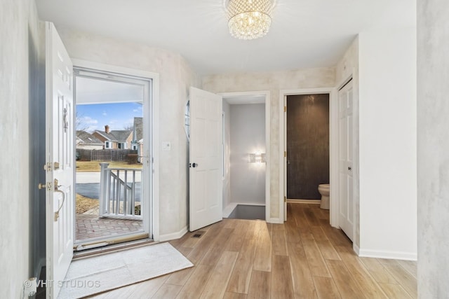 foyer with a notable chandelier and light wood-type flooring