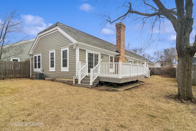 rear view of property featuring a deck, a lawn, and central air condition unit