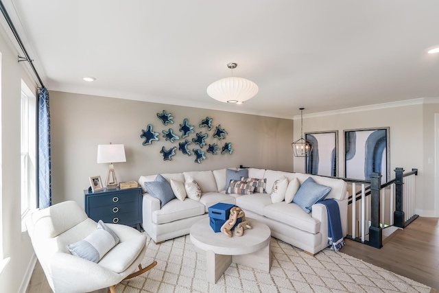 living room featuring crown molding, light hardwood / wood-style floors, and a healthy amount of sunlight