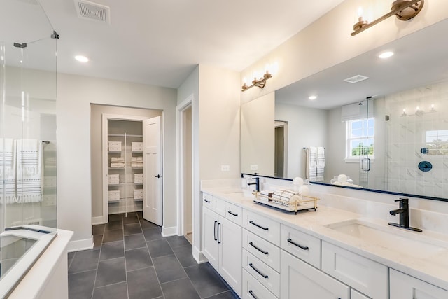 bathroom with vanity, a shower with shower door, and tile patterned floors