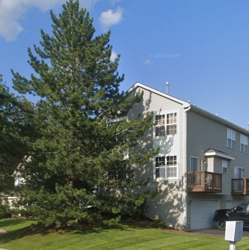 view of property exterior featuring a garage and a lawn