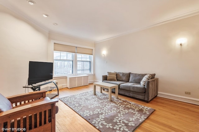 living room featuring ornamental molding, radiator, and light wood-type flooring