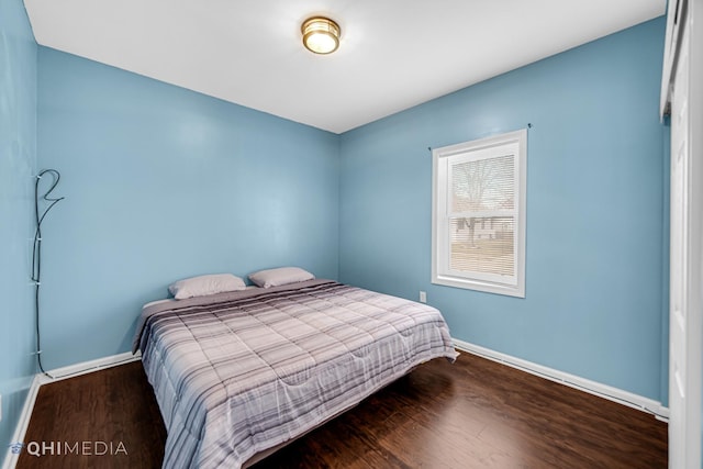 bedroom with baseboards and wood finished floors