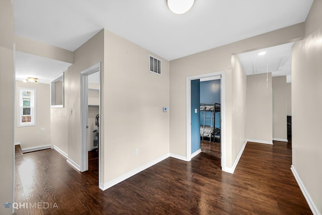 interior space with baseboards, attic access, visible vents, and wood finished floors