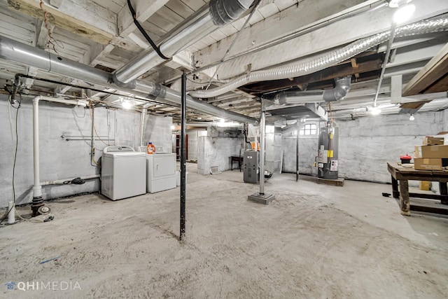 basement with water heater, washer and clothes dryer, and heating unit