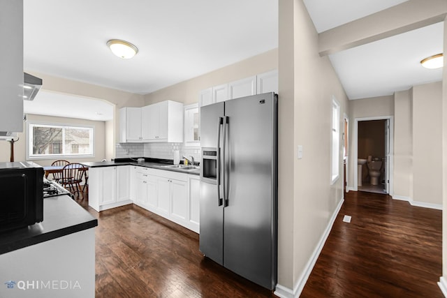 kitchen with a sink, white cabinetry, stainless steel fridge with ice dispenser, dark wood-style floors, and tasteful backsplash