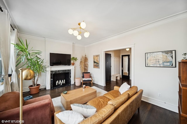 living room with crown molding, dark wood-type flooring, an inviting chandelier, and a fireplace