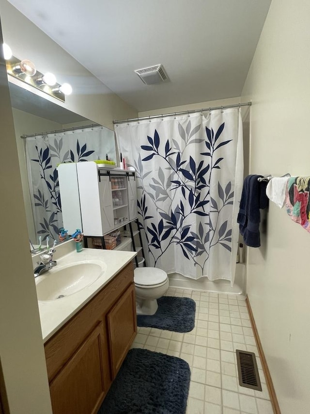 bathroom with tile patterned floors, vanity, toilet, and curtained shower