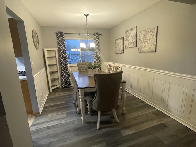 dining space with an inviting chandelier and dark hardwood / wood-style flooring