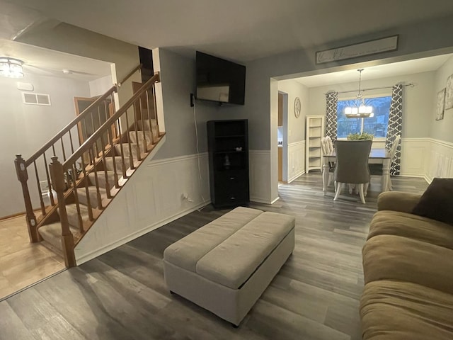 living room with hardwood / wood-style floors and an inviting chandelier