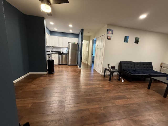 living room with ceiling fan, sink, and dark hardwood / wood-style flooring