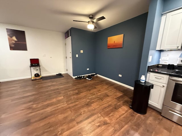 interior space with ceiling fan, stainless steel range with electric cooktop, dark hardwood / wood-style floors, and white cabinets