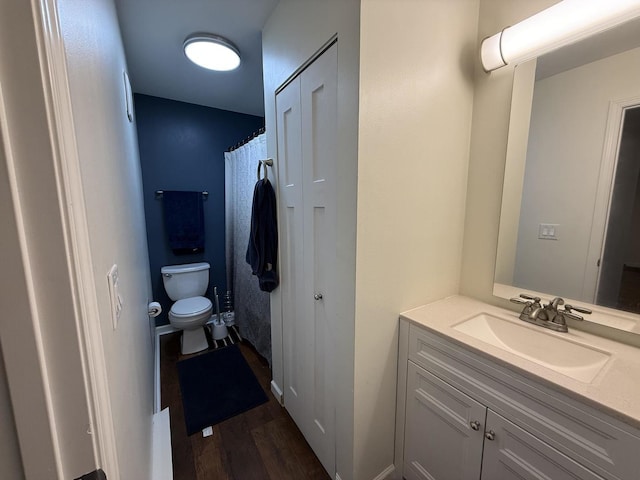 bathroom with hardwood / wood-style flooring, vanity, and toilet