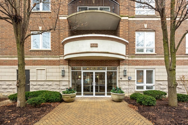 view of exterior entry with a balcony