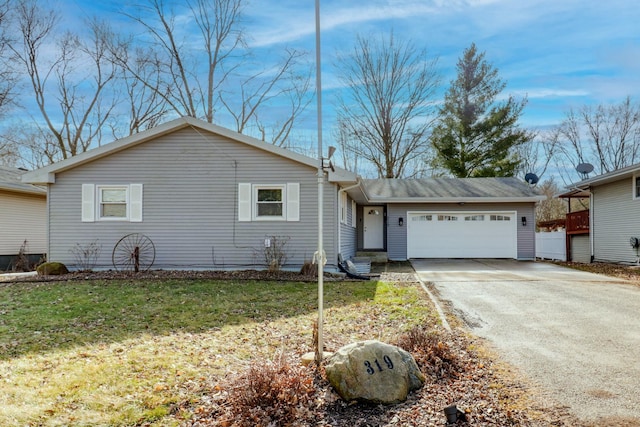 ranch-style home with a garage and a front lawn