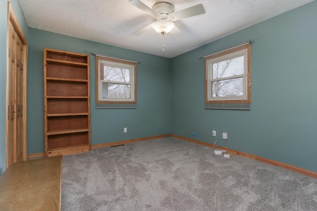 spare room with ceiling fan, carpet floors, and a textured ceiling