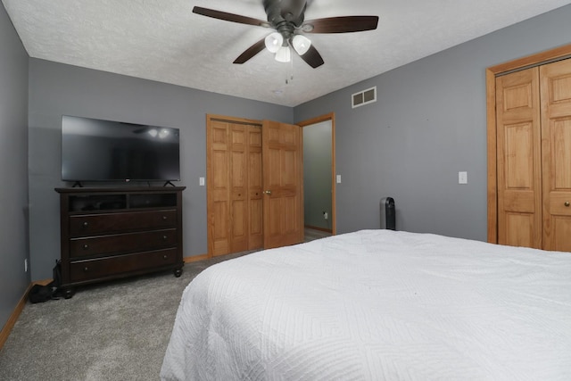 bedroom featuring ceiling fan, light colored carpet, and a textured ceiling