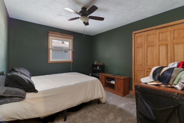 carpeted bedroom featuring ceiling fan, a closet, and a textured ceiling