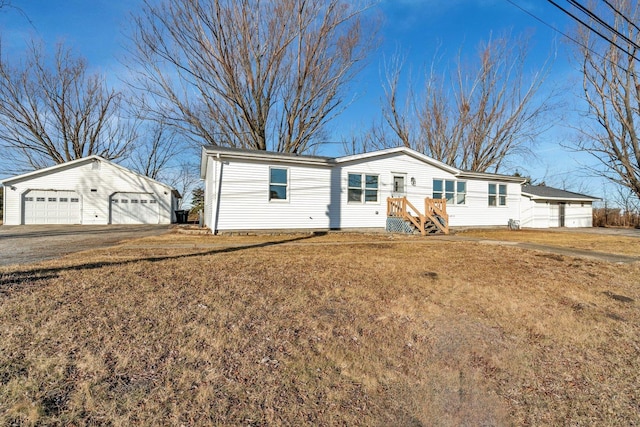 view of front of property with an outbuilding, a garage, and a front lawn