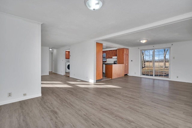 unfurnished living room with washer / clothes dryer and hardwood / wood-style floors