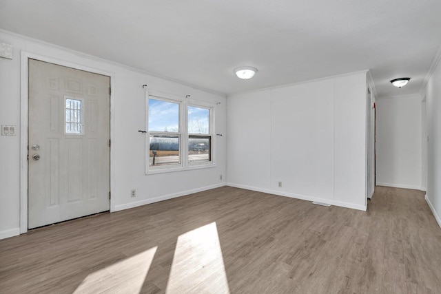 entrance foyer featuring crown molding and light hardwood / wood-style floors